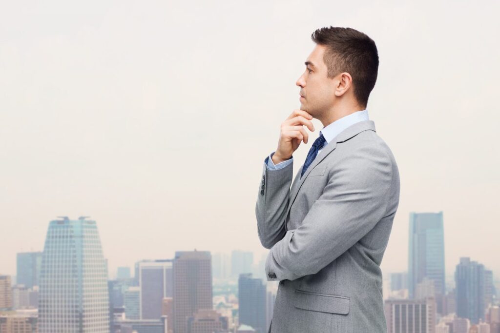 Man in a suit looking thoughtfully across a city skyline