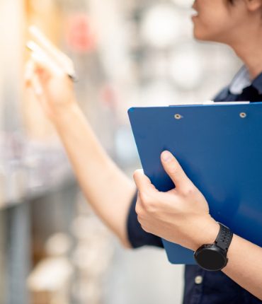 Warehouse worker checking stock against a clipboard