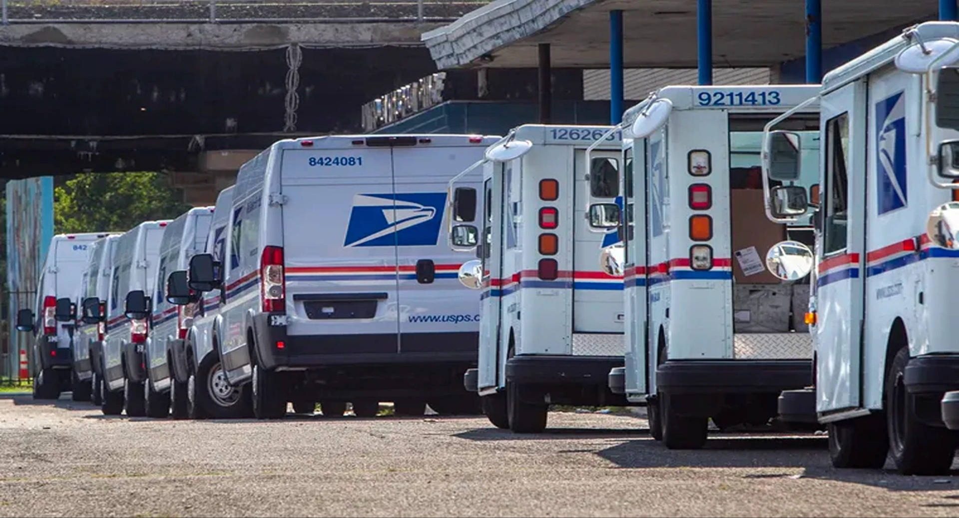 A row of parked USPS mail trucks